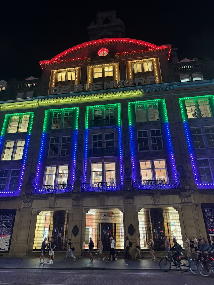 de Bijenkorf department store lit up in rainbow colours for Amsterdam World Pride 2026.