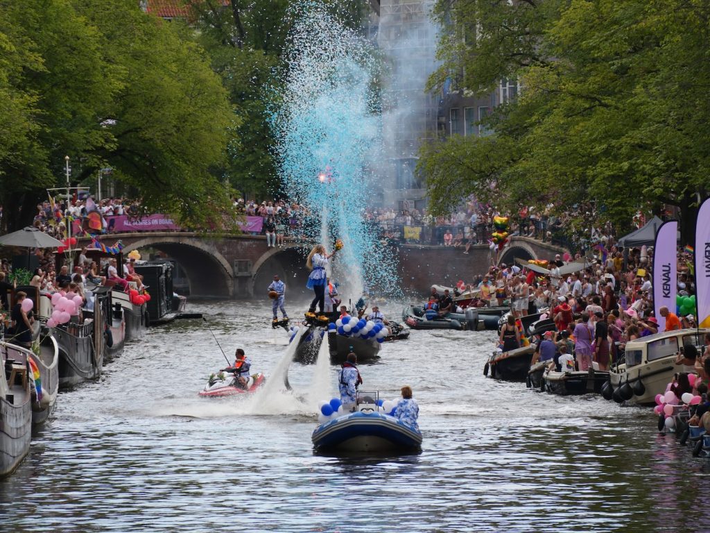 Acrobats using jets to float over Amsterdam canal.