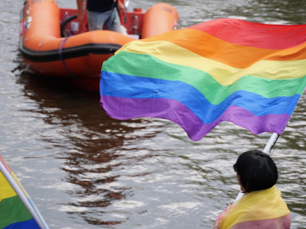Rainbow Flag against the canal waters and safety boat at the Amsterdam World Pride 2026 Canal Parade